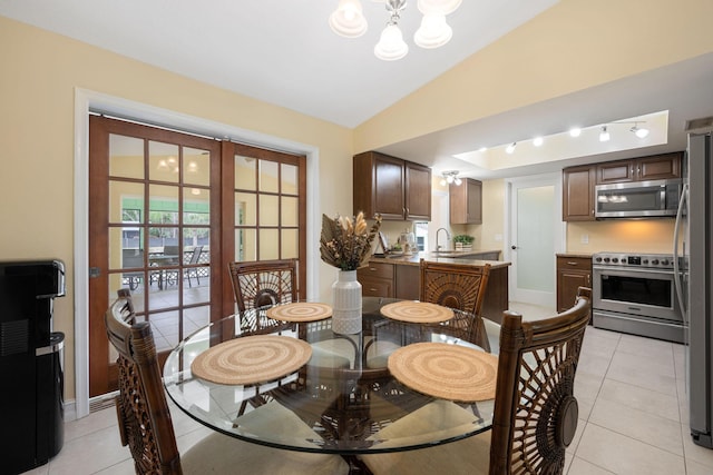 dining area featuring baseboards, lofted ceiling, an inviting chandelier, french doors, and light tile patterned flooring