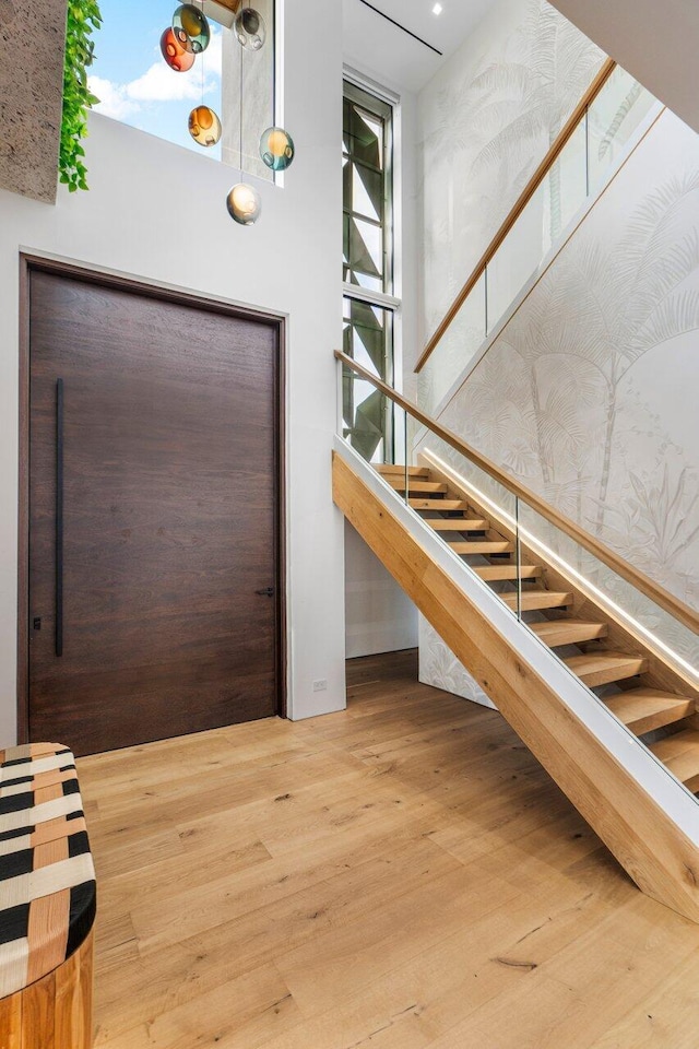 staircase with a high ceiling and wood finished floors