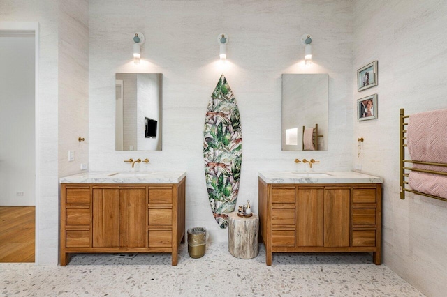 full bath with a sink and two vanities