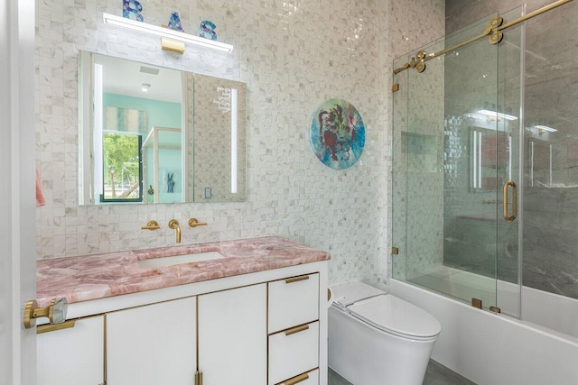 full bathroom with toilet, bath / shower combo with glass door, and vanity