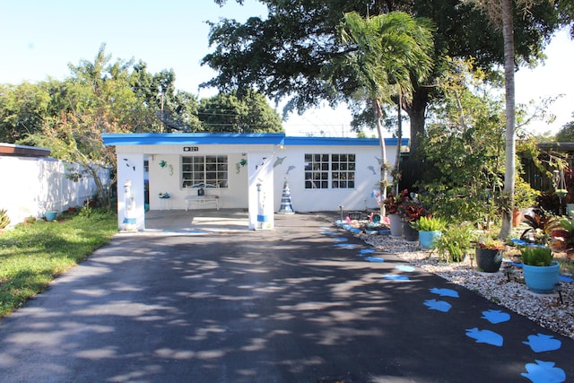 view of front of home featuring fence, driveway, and stucco siding