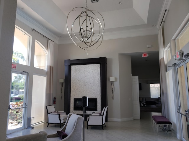 home office featuring a tray ceiling, an inviting chandelier, a towering ceiling, and crown molding