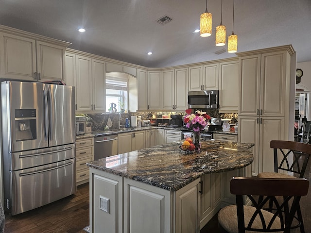 kitchen with visible vents, appliances with stainless steel finishes, decorative light fixtures, and a center island