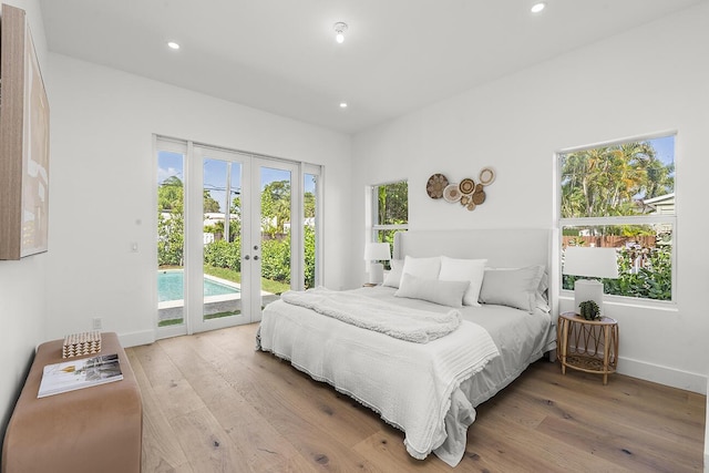 bedroom with light wood finished floors, french doors, multiple windows, and access to exterior