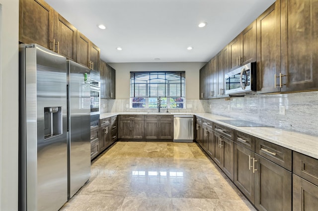 kitchen with tasteful backsplash, light stone counters, stainless steel appliances, and recessed lighting