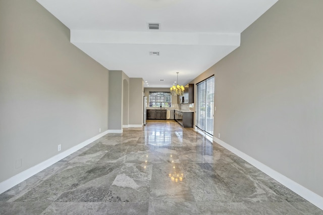 interior space with visible vents, baseboards, and a chandelier