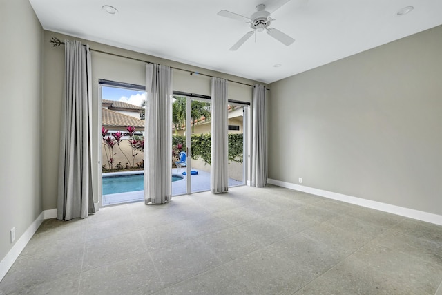 unfurnished room featuring light speckled floor, a ceiling fan, and baseboards