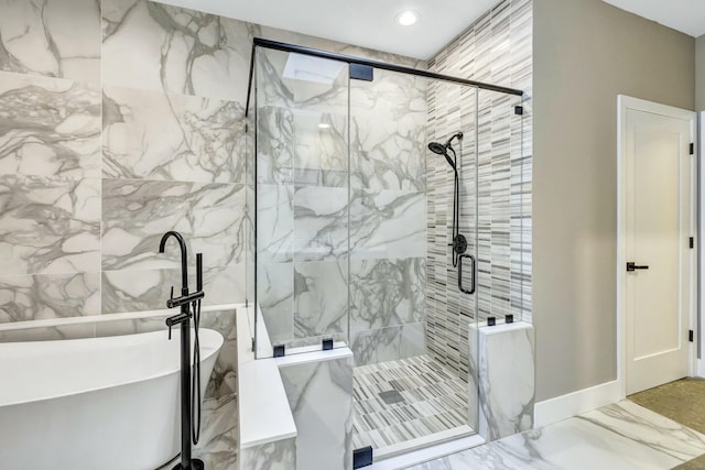 full bath featuring marble finish floor, recessed lighting, a freestanding bath, a stall shower, and a sink