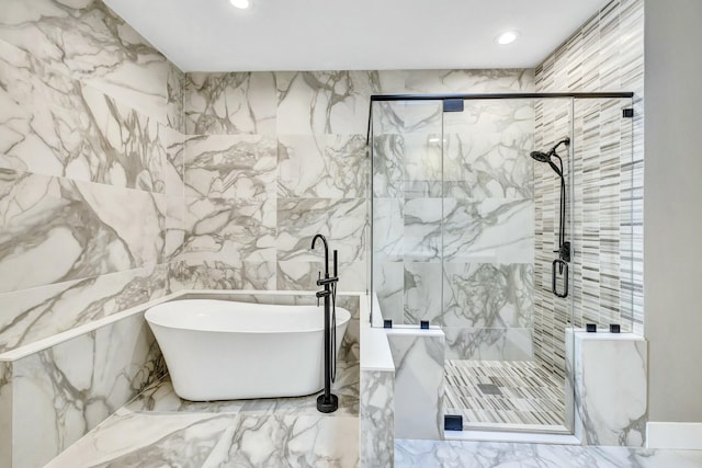 full bath featuring recessed lighting, a freestanding bath, a marble finish shower, and stone wall