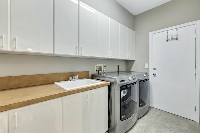 washroom with cabinet space, a sink, and washer and clothes dryer