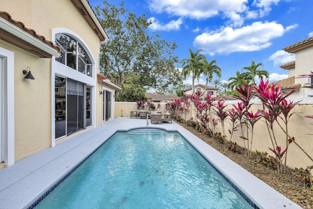 view of pool with an outdoor living space, a patio area, a fenced backyard, and a fenced in pool