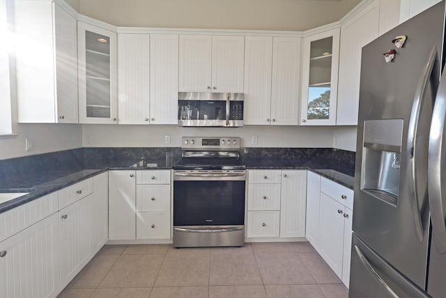 kitchen with stainless steel appliances, glass insert cabinets, and white cabinets