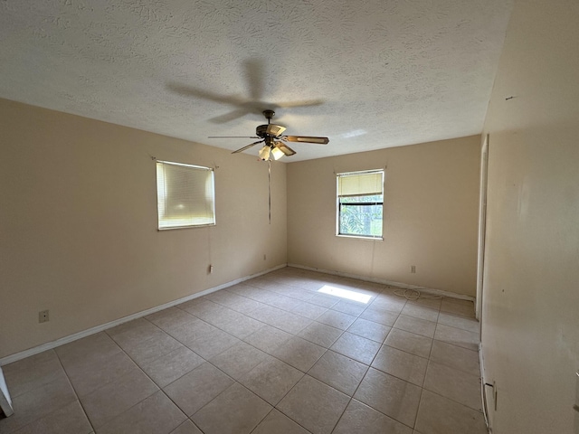 unfurnished room with a textured ceiling, baseboards, a ceiling fan, and light tile patterned flooring