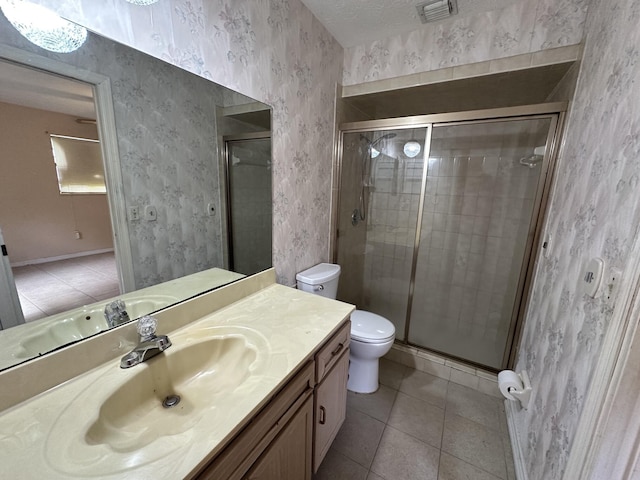 bathroom featuring toilet, visible vents, vanity, a stall shower, and wallpapered walls