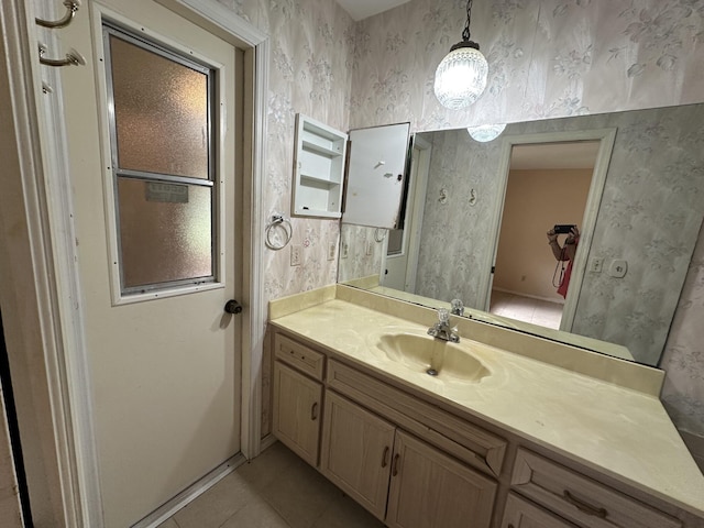 bathroom featuring tile patterned floors, vanity, and wallpapered walls