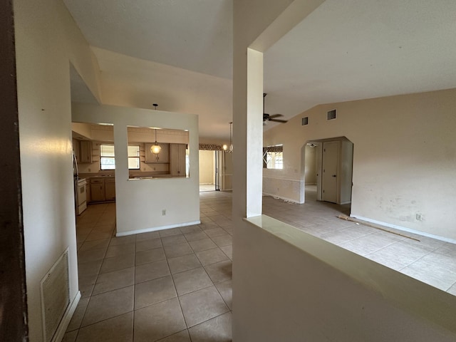 interior space featuring lofted ceiling, visible vents, ceiling fan, and light tile patterned floors