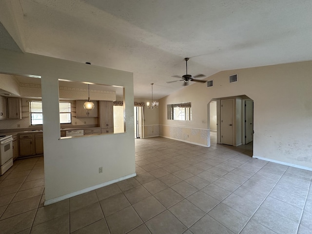 unfurnished living room with ceiling fan with notable chandelier, visible vents, lofted ceiling, and light tile patterned flooring