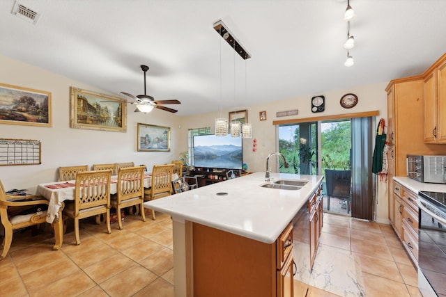 kitchen featuring a center island with sink, hanging light fixtures, stainless steel appliances, light countertops, and a sink