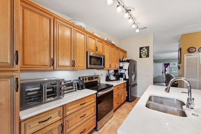 kitchen with a sink, stainless steel appliances, and light countertops