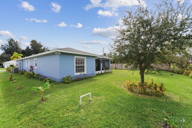 exterior space with fence, a lawn, and stucco siding