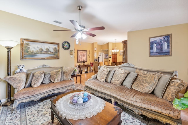 living room featuring ceiling fan with notable chandelier, wood finished floors, and visible vents