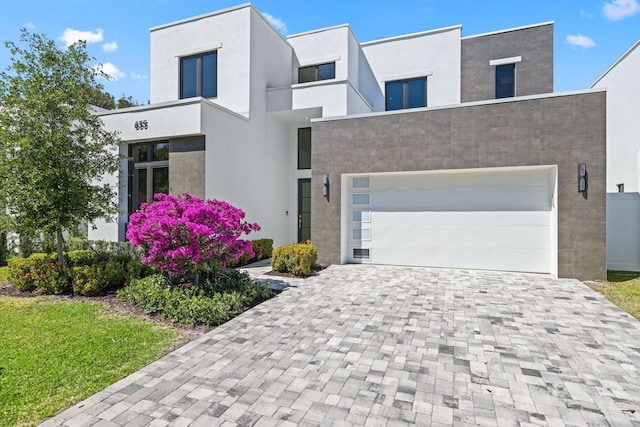 contemporary home with stucco siding and decorative driveway