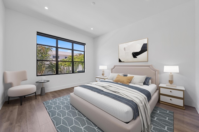 bedroom with baseboards, wood finished floors, and recessed lighting
