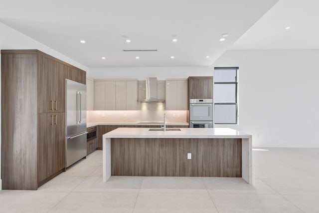 kitchen with stainless steel appliances, light countertops, a sink, modern cabinets, and a spacious island
