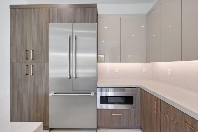 kitchen with light stone countertops, modern cabinets, and appliances with stainless steel finishes