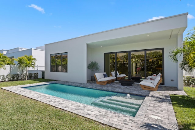 back of property featuring fence, a lawn, a fenced in pool, and stucco siding