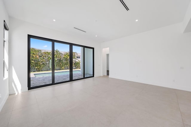 empty room with baseboards, light tile patterned flooring, visible vents, and recessed lighting