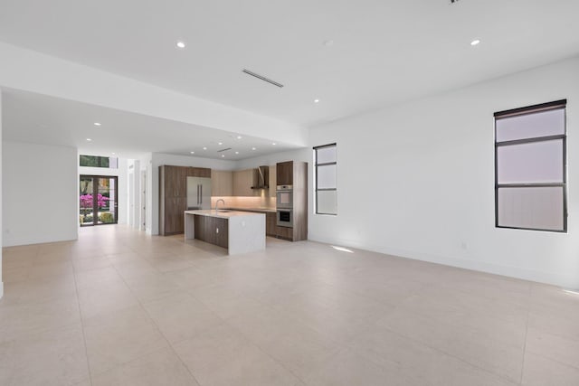 unfurnished living room with recessed lighting, a wealth of natural light, and a sink