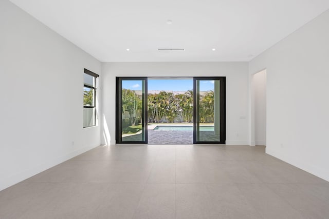 unfurnished room featuring baseboards, visible vents, and recessed lighting
