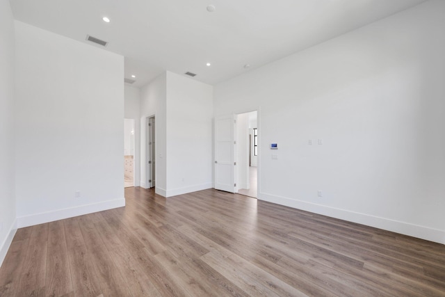 empty room featuring visible vents, baseboards, and wood finished floors