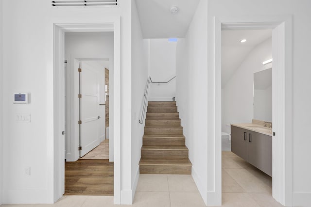 stairs with tile patterned floors, baseboards, and recessed lighting