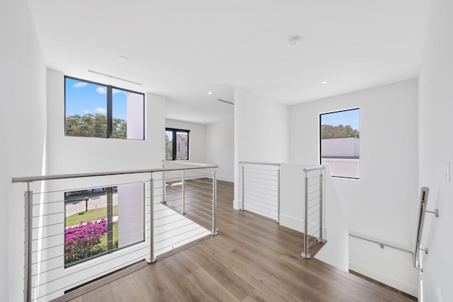 empty room featuring recessed lighting, wood finished floors, and baseboards