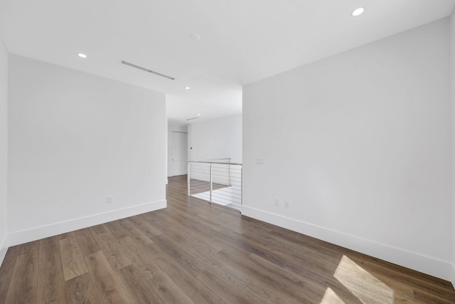 unfurnished room with baseboards, wood finished floors, and recessed lighting