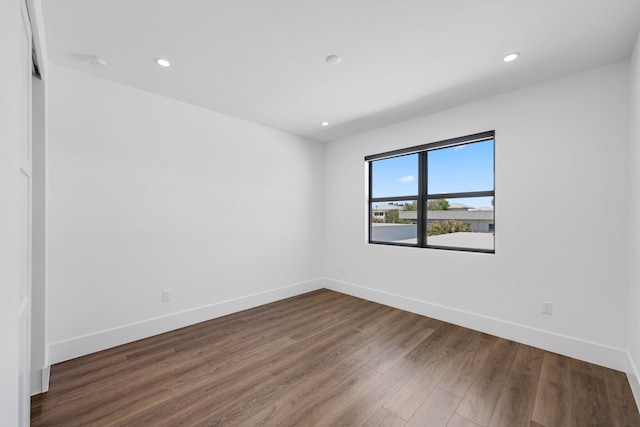 empty room featuring baseboards, recessed lighting, and dark wood finished floors