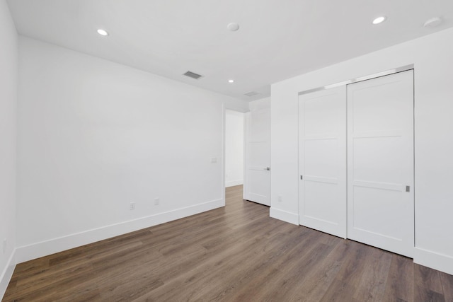 unfurnished bedroom with recessed lighting, wood finished floors, visible vents, and baseboards