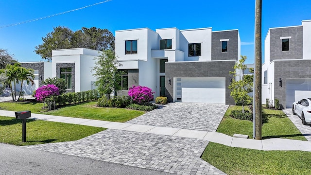 view of front of house with a garage, stucco siding, decorative driveway, and a front lawn