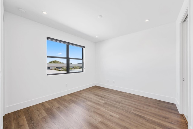 unfurnished bedroom with baseboards, wood finished floors, and recessed lighting