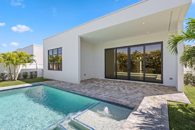 back of property with a patio area, an outdoor pool, stucco siding, and fence