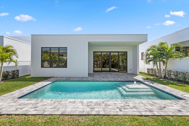 back of house with an outdoor pool, stucco siding, and fence
