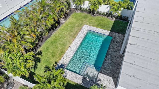 view of swimming pool with a fenced backyard and a lawn