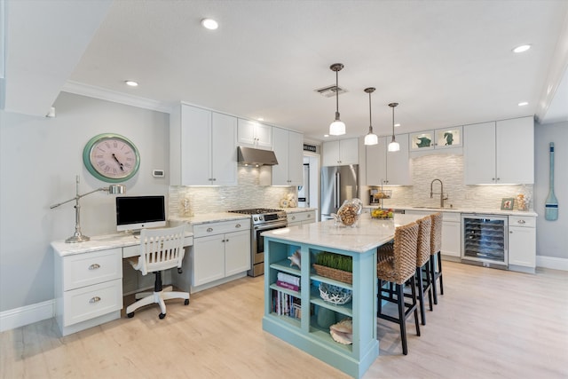 kitchen featuring under cabinet range hood, wine cooler, a breakfast bar, appliances with stainless steel finishes, and a sink