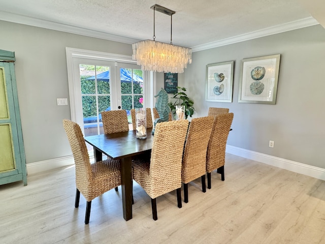 dining area with a chandelier, a textured ceiling, crown molding, and light wood-style floors