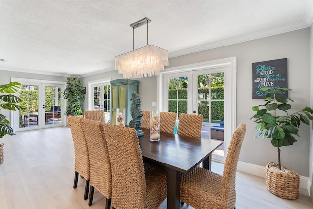 dining room featuring french doors, a notable chandelier, and ornamental molding