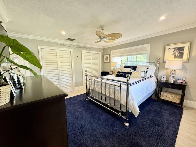 bedroom with a textured ceiling, crown molding, and wood finished floors