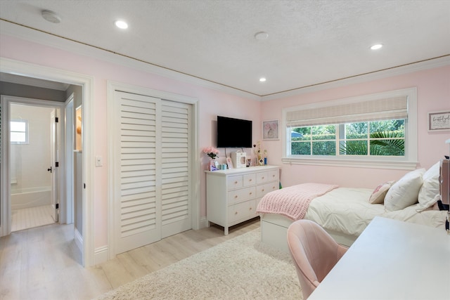 bedroom with ornamental molding, recessed lighting, light wood-style flooring, a closet, and a textured ceiling