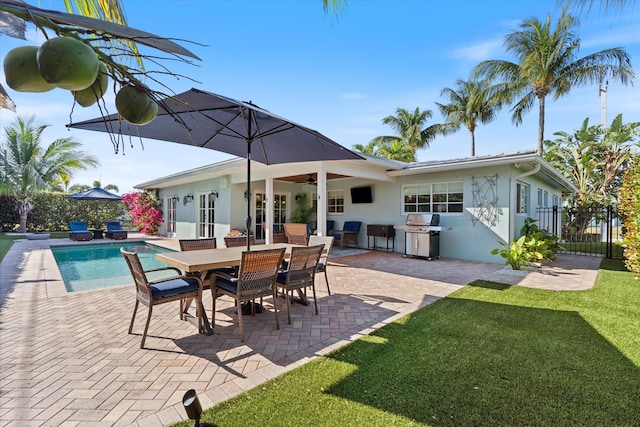 exterior space featuring fence, a yard, ceiling fan, a patio area, and a grill